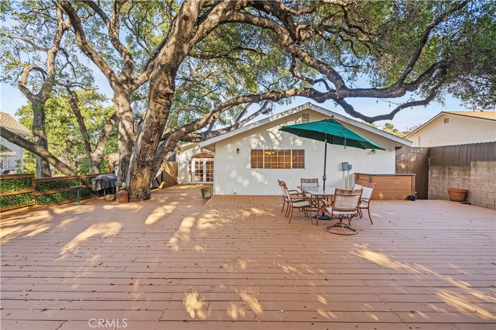 24123 Wildwood Canyon Road Newhall, CA 91321 - Photo 25 of 32 a backyard of a house with table and chairs under a large tree