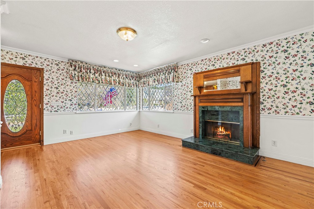 24123 Wildwood Canyon Road Newhall, CA 91321 - Photo 3 of 32 a view of an empty room with wooden floor and a fireplace