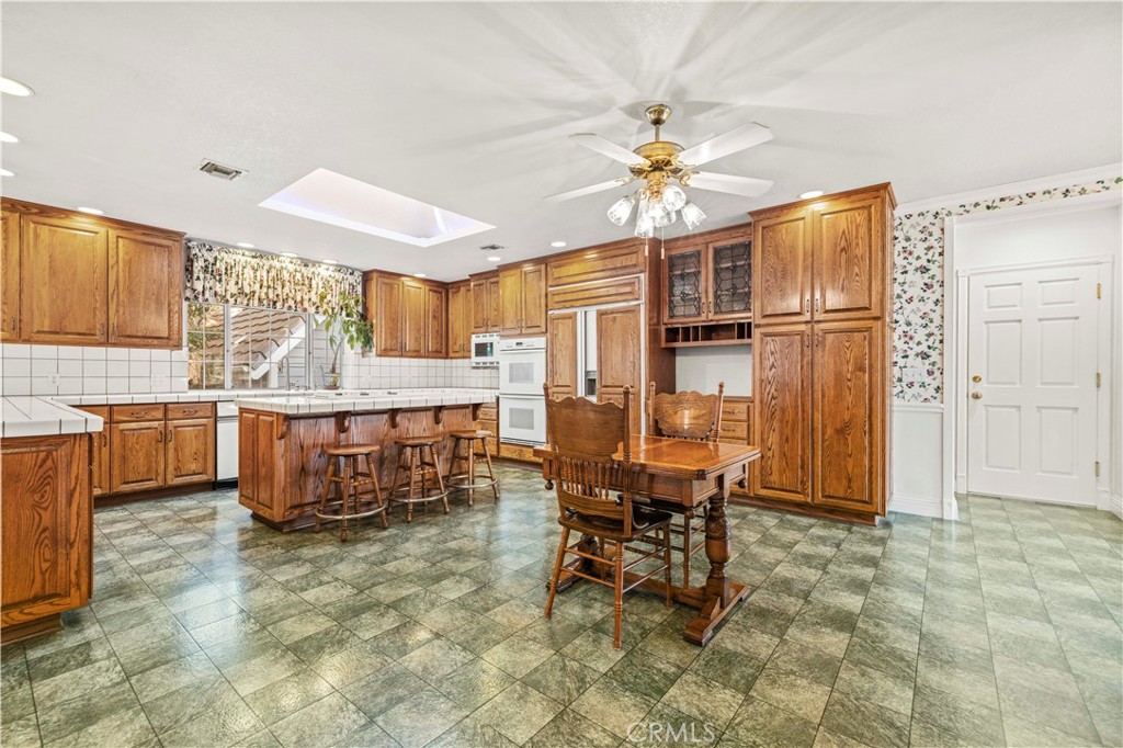 24123 Wildwood Canyon Road Newhall, CA 91321 - Photo 4 of 32 a dining room filled a chandelier and kitchen view