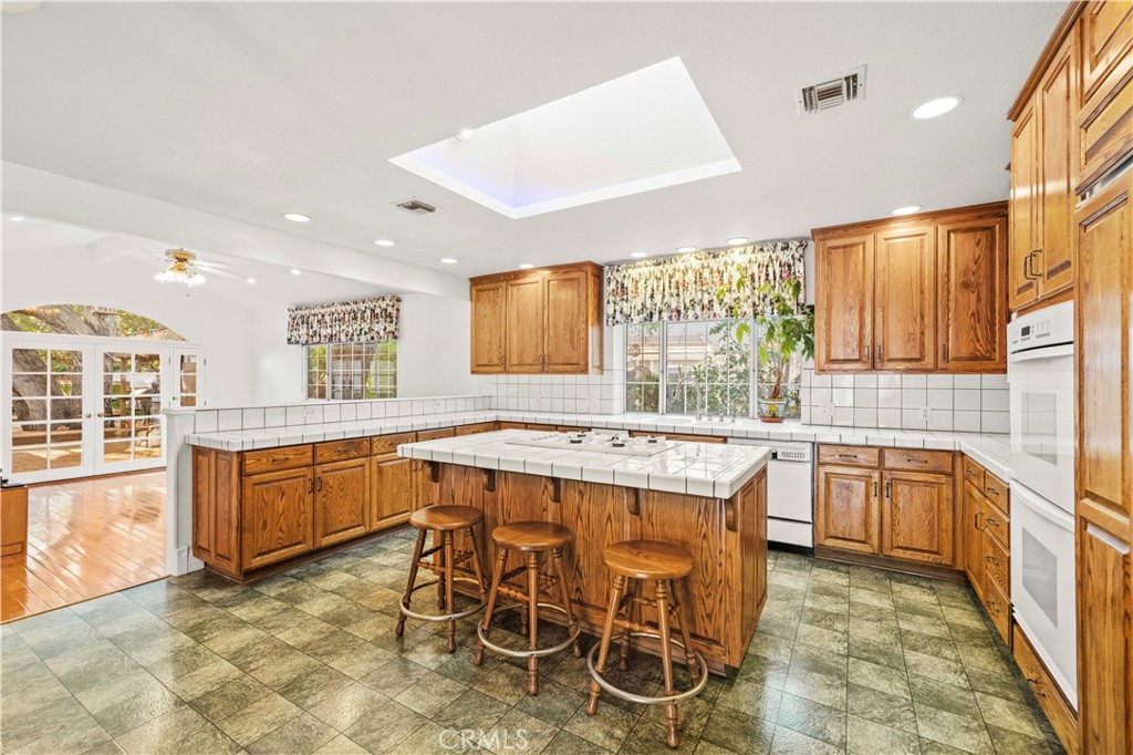 24123 Wildwood Canyon Road Newhall, CA 91321 - Photo 6 of 32 a large kitchen with kitchen island granite countertop counter space a sink appliances and cabinets