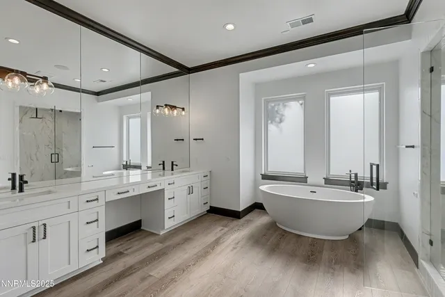a spacious bathroom with a double vanity sink a mirror and a bathtub