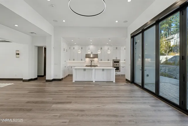 a large white kitchen with a large window appliances and cabinets