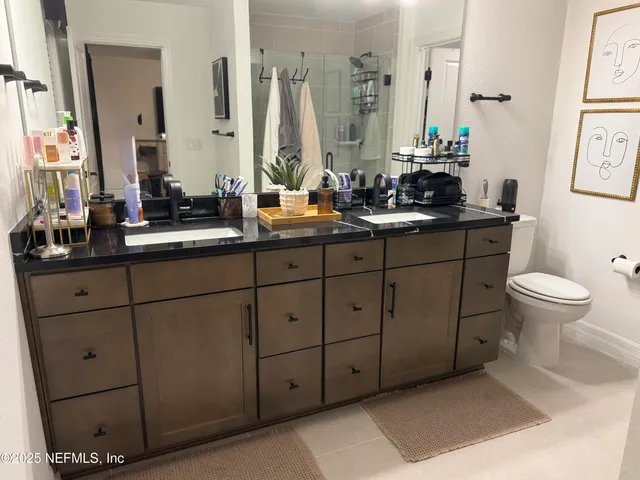 a bathroom with a double vanity sink toilet and a mirror