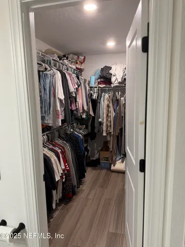a view of walk in closet with clothes and shoes