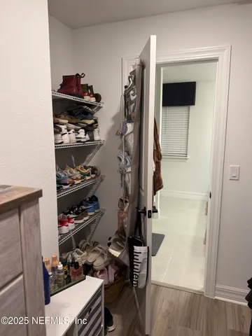 a view of walk in closet with clothes and shoes