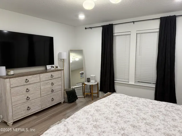 a bedroom with a bed and a flat tv screen in it
