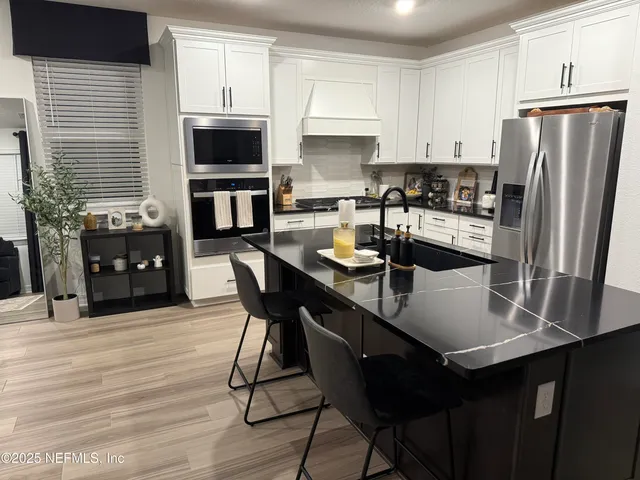 a kitchen with a dining table chairs and refrigerator