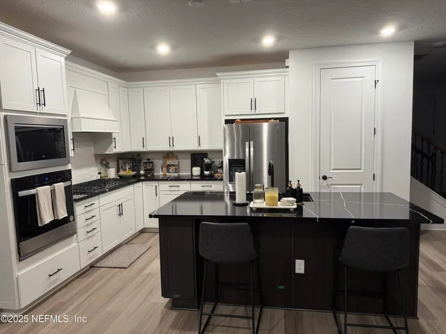 a kitchen with stainless steel appliances a sink a stove a refrigerator and cabinets