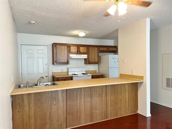 a large kitchen with a wooden floor and a sink