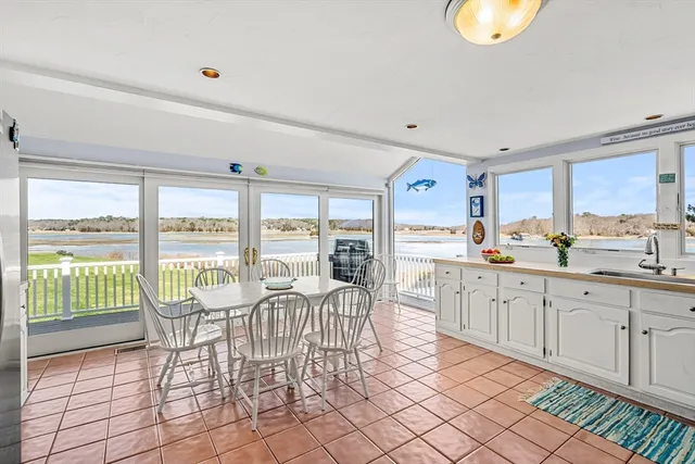 a kitchen with a table chairs refrigerator and cabinets
