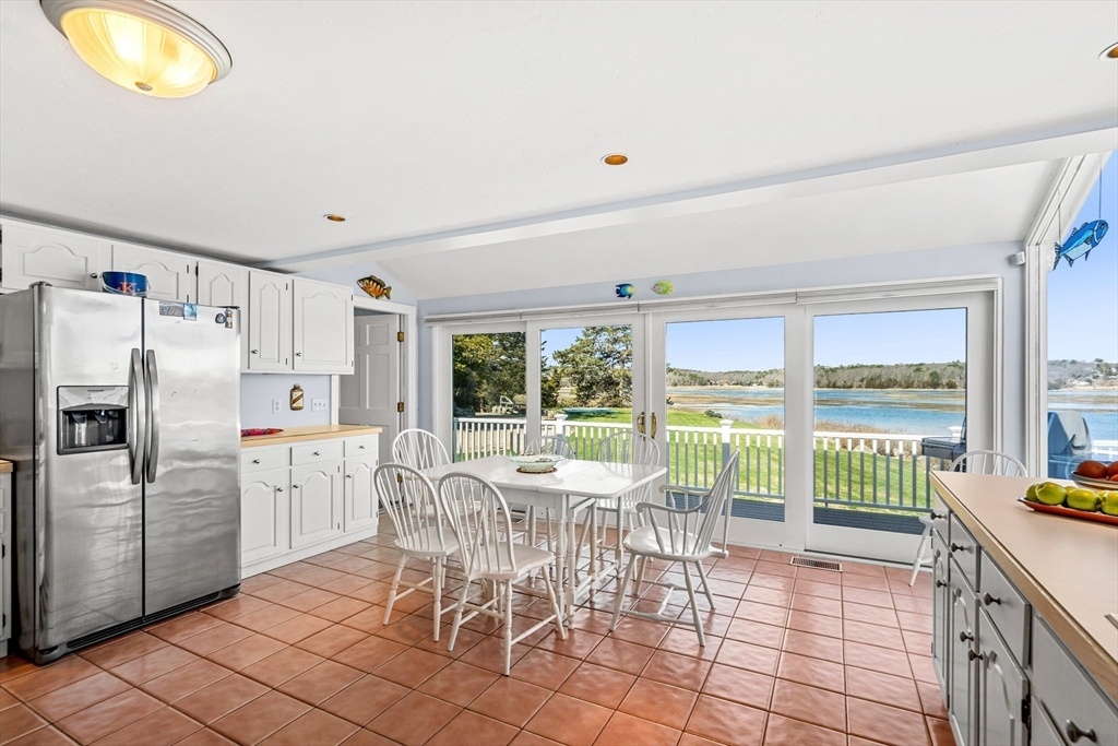 62 Crafts Road Gloucester, MA 01930 - Photo 17 of 40 a kitchen with a table chairs refrigerator and cabinets