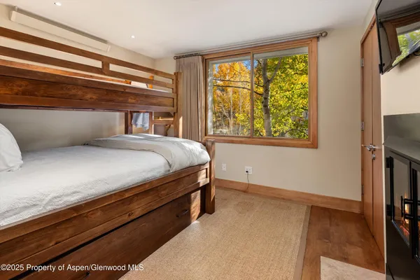 a bedroom with a bed and a flat tv screen on dresser