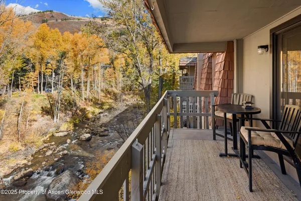 a balcony with chairs and wooden floor