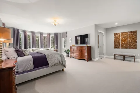 a spacious bedroom with a bed and glass wall door