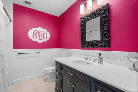 a bathroom with a sink a toilet and mirror