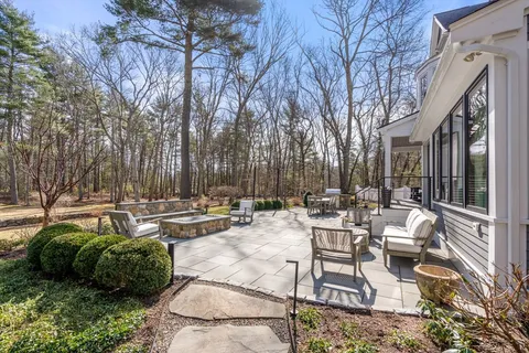 a view of a patio with couches and table and chairs and wooden fence
