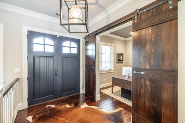 a view of a hallway with wooden floor and entryway