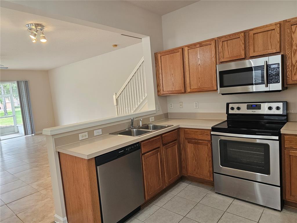 26638 Castleview Way Wesley Chapel, FL 33544 - Photo 7 of 24 a kitchen with stainless steel appliances granite countertop a sink stove and microwave