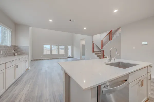 a kitchen with a sink a large window and wooden floor