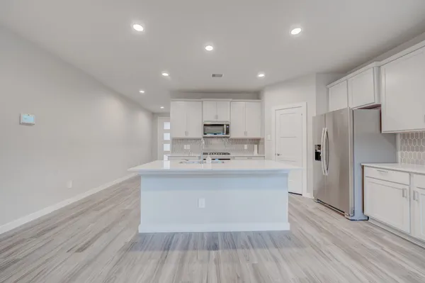 a view of kitchen center island wooden cabinets and stainless steel appliances