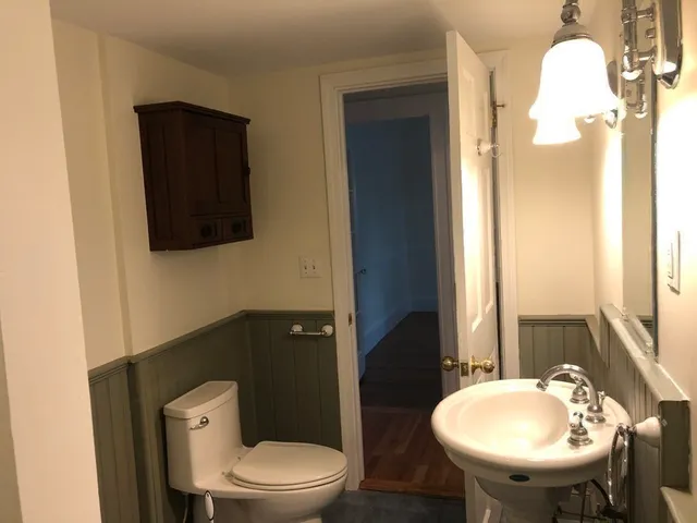 a bathroom with a toilet a sink and mirror