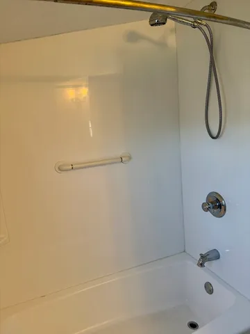 a bathroom with a bath tub with a shower