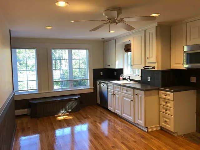 a kitchen with granite countertop a stove a sink and a microwave