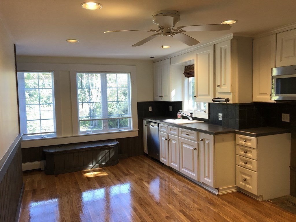 24 State Street, Unit 2 Wellesley, MA 02482 - Photo 2 of 21 a kitchen with granite countertop a stove a sink and a microwave