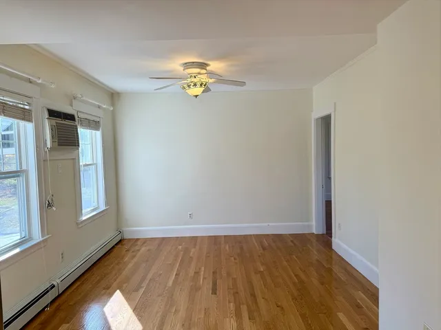 a view of a room with wooden floor and window