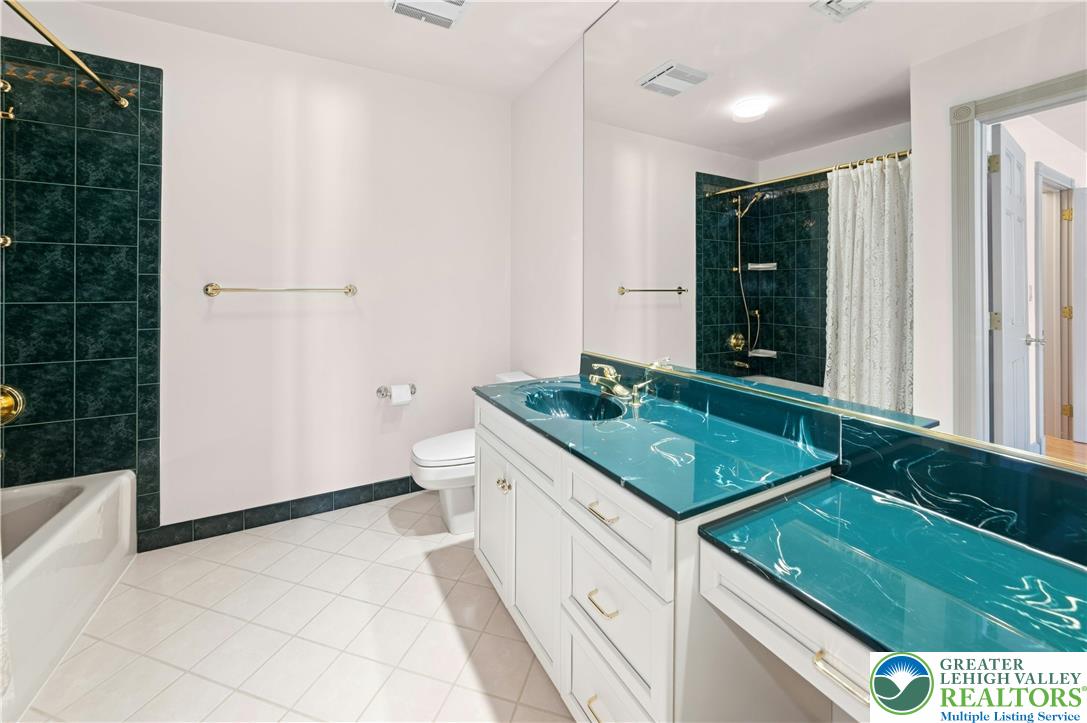 3640 Manor Road Bethlehem, PA 18020 - Photo 34 of 46 a bathroom with a granite countertop sink a toilet a mirror and shower