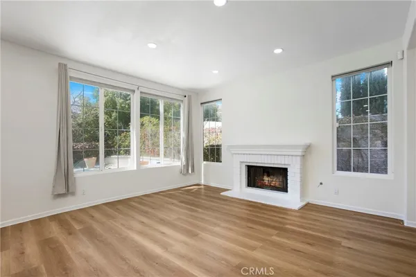 a view of empty room with wooden floor and fireplace