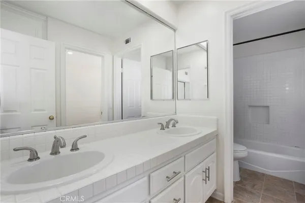 a bathroom with a double vanity sink mirror double and bathtub