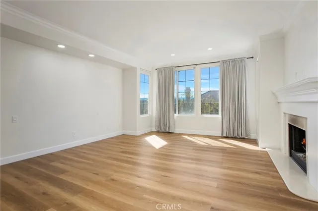 a view of an empty room with a fireplace and a window