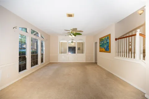 an empty room with shelves and chandelier fan