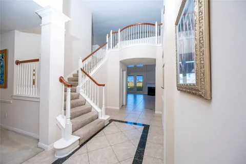 a view of an empty room with kitchen and fireplace