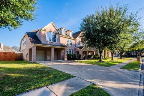 a view of a big house with a big yard and large trees