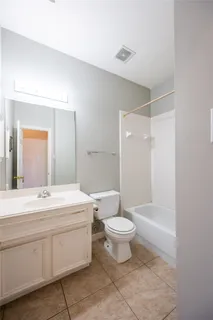 a view of an empty room with chandelier fan and a window