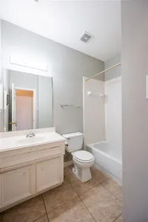 a view of an empty room with chandelier fan and a window