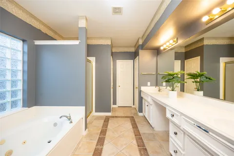a bathroom with a tub mirror and sink