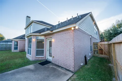 a view of a house with a yard and large trees