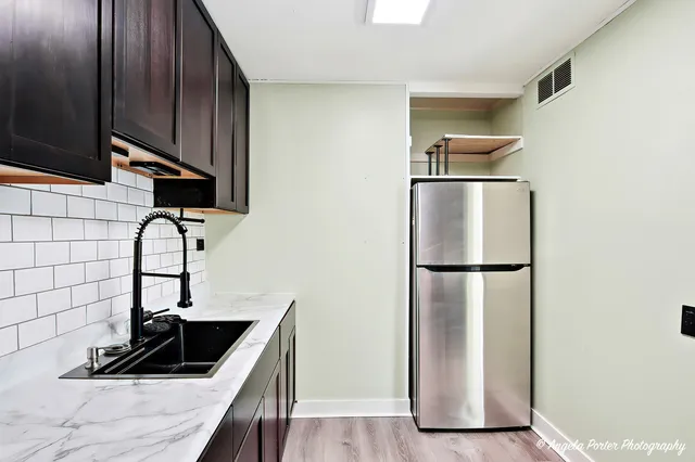 a kitchen with a sink a refrigerator and cabinets