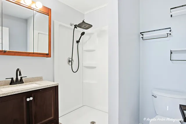 a bathroom with a sink vanity mirror and toilet