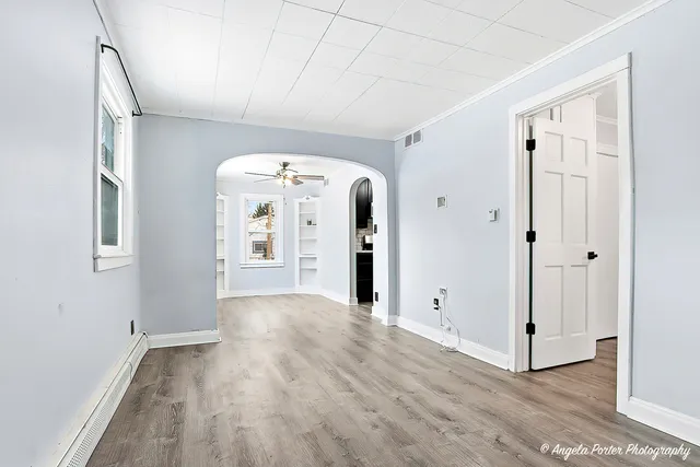 a view of a big room with wooden floor and windows
