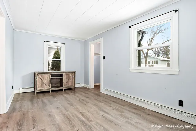 an empty room with a window and wooden floor