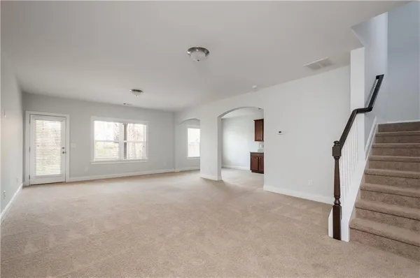 an empty room with ceiling fan and windows