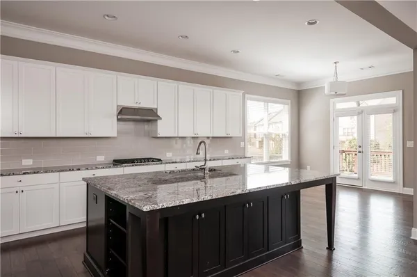 a kitchen with granite countertop a sink and cabinets
