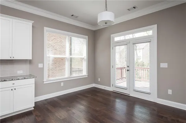 a view of a kitchen with wooden floor and natural light