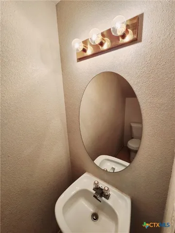 a bathroom with a toilet sink and mirror