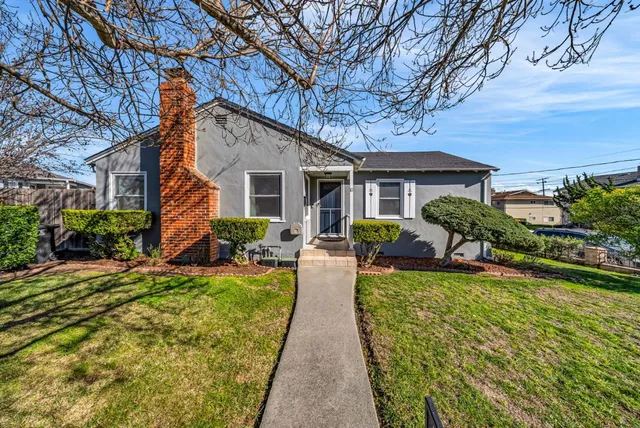a view of a house with backyard and sitting area