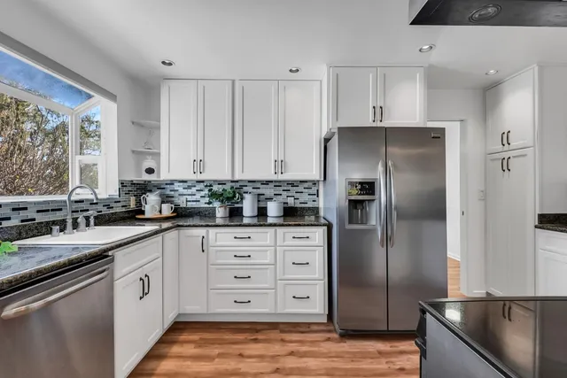 a kitchen with white cabinets and stainless steel appliances